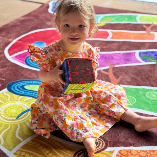 Serpents and Sticks rug game in classroom — children playing active Indigenous art rug game with soft dice during group learning time